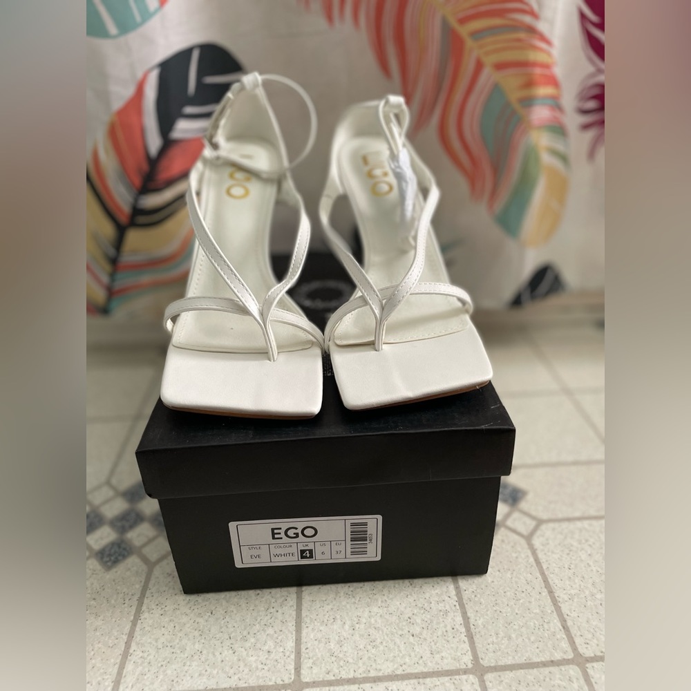 Square toe strappy heel in white faux leather.